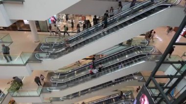 Tiflis, Yunanistan - 2 Mayıs 2024: Çok katlı alışveriş merkezlerinden geçen müşteri ve çalışanlara yukarıdan bir bakış. Yürüyen merdivenler ve perakende mağazaları görülebilir.