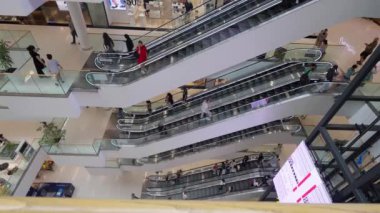 Tiflis, Yunanistan - 2 Mayıs 2024: Çok katlı alışveriş merkezlerinden geçen müşteri ve çalışanlara yukarıdan bir bakış. Yürüyen merdivenler ve perakende mağazaları görülebilir.