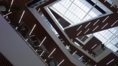 Bulanık görüntüler, alışveriş merkezlerinde yürüyen merdivenlere binen müşterileri ve banliyö sakinlerini yakalıyor.