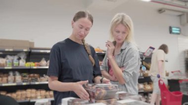 İki genç kadın süpermarkette hamur işi seçerken hararetli tartışmalara girişirler. Seçeneklerini tartarlar, hangi lezzetli yiyecekleri alacaklarını düşünürler.