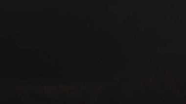 Aralıklı olarak şimşekler çakıyor, fırtınalı okyanusların üzerindeki karanlık ve fırtınalı bulutları aydınlatıyor. Sahne, gece fırtınasının ham güç ve enerjisini deniz üzerinde yakalıyor.