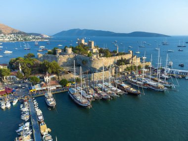 Türkiye 'nin Mugla ilçesindeki Bodrum ve antik Kalesi' nin güzel, yat dolu limanının insansız hava aracı görüntüsü gün batımında.