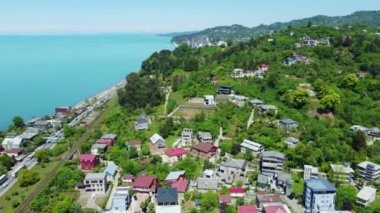 İnsansız hava aracı kamerası, yemyeşil tepelerin arasına yuva yapmış, Gürcistan ve Makhinjauri kıyı şeridinin güzelliğini ve cazibesini gözler önüne seriyor..