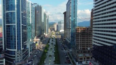 Kazıcı, nehrin yakınındaki inşaat alanında, çöp kamyonuna kum yüklüyor. İnşaat alanında kazıcının çöp kamyonunu yüklerken en tepeden aşağı bakışı. Kazıcı yerde çukur kazıyor.