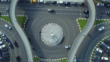 Arabalar ana heykelle kavşağın etrafında dönüyorlar. Yayalar, Gürcistan 'ın Batumi kentindeki yaya trafiğinin ve yaya güvenliğinin dinamiklerinin altını çizerek, belirlenmiş yaya geçidinde karşıdan karşıya geçiyorlar..