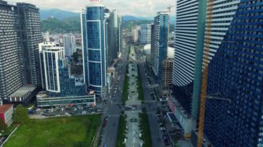 Kazıcı, nehrin yakınındaki inşaat alanında, çöp kamyonuna kum yüklüyor. İnşaat alanında kazıcının çöp kamyonunu yüklerken en tepeden aşağı bakışı. Kazıcı yerde çukur kazıyor.