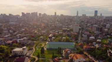 Gürcistan 'daki Batumi' nin canlı şehir manzarası, güneşli gökyüzünün altında modern apartman ve binaların karışımını gösteriyor..