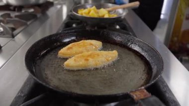 Mısır hamuruna dayalı aşçı kızartma tabağı, profesyonel ocakta tavada McDi, paslanmaz çelik ekipmanlarla dolu gürültülü restoran mutfağında aşçılık becerilerini gösteriyor. Gürcistan mutfağı