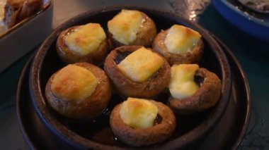 Lezzetli mantarlar, peynirle doldurulmuş, profesyonel fırında pişirilmiş. Yemek, aç restoran misafirlerine servis edilmeye hazır..