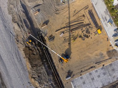 Deniz kıyısında inşaat çalışmaları var. Ağır makineler, temeli su ve fırtına dalgalarından güçlendirmek için çalışıyor. İnsansız hava aracından görüntüle.