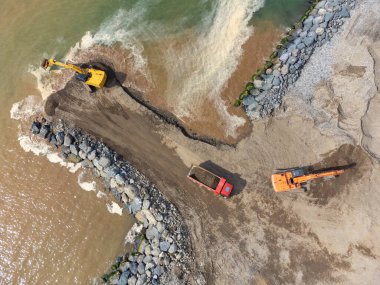 Kum kamyonlu kazıcılar deniz kıyısında, nehirde ya da barajda çalışıyorlar..