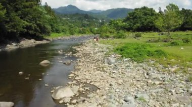 Kızın iki arkadaşı, turistler, tatillerinin tadını çıkarıyorlar, Gürcistan 'daki dağ nehri kıyısında yürüyorlar ve arkadaşlıklarını güçlendiriyorlar. Turizm merkezi, insansız hava aracı manzarası.