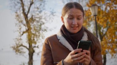 Genç kadın telefonunda kısa mesaj okuyor ve bir dizi olumsuz duygu yaşıyor. Karmaşadan üzüntüye ve öfkeye.