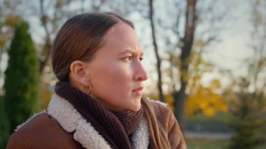 Uykulu kadın sonbahar parkında bankta oturuyor, esniyor; uykusuz geceden esniyor, yorgunluk, uykusuzluk, yorgunluk, stres, yorgunluk