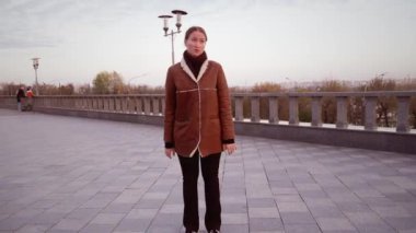Genç bir kadın hayal kırıklığını ve rahatsızlığını ifade ediyor. Duygularını dışa vuruyor. Stres, endişe ve üzüntü duyguları, şehir sonbahar ortamındaki sorunlu durumunu yansıtıyor..