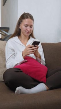 Beyaz gömlekli genç iş kadını, dijital içerikle uğraşırken şaşkınlık, güvensizlik, hayal kırıklığı ve hayal kırıklığı gibi duygular gösteren akıllı telefonuyla okuyor.