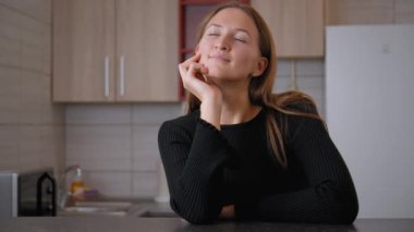 Genç bir kadın mutfak tezgahına yaslanmış, derin düşüncelere dalarken çenesini elinin üzerinde dinlendiriyordu. Huzur dolu bir an uzayı dolduruyor. Huzurlu ve düşünceli bir mola veriyor.