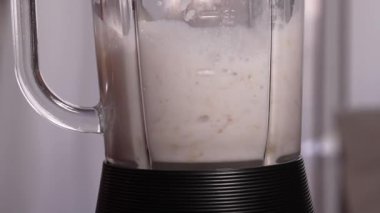 Elektrikli blender meyve suyu için malzemeleri karıştırarak meyve ve sebze karışımı olarak kabarcıklar yaratır. Süreç gösterileri kremalı, lezzetli içecek hazırlama gerçek zamanlı Yavaş çekim.