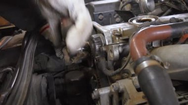 Araba tamircileri motorlar üzerinde çalışır, anahtarlar ve cırcırlarla zamanlayıcı kemerlerini sıkarlar. Süreç, otomotiv onarımı ve bakımında nitelikli işçilik gösteriyor