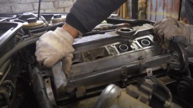 Tamirci dikkatli bir şekilde motor kapağını kaldırır, atölyede arabanın motorunun karmaşık iç kısımlarını ortaya çıkarır. Detaylı Mekanik Bakım Genel Görünümü