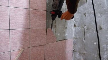 İnşaatçılar eski fayansları keski, pervane ve çekiçle sökerek tamir için yüzey hazırlıyorlar. Toz ve enkaz uzayı dönüştürme sürecinde birikiyor.