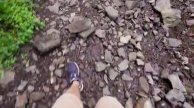 Turist, yemyeşil ormanlardaki engebeli kayalık arazide gezinerek, birinci şahıs manzaralı, pitoresk doğal ortamda zorlu vahşi doğa yolculuğunu gerçekleştiriyor. feet.