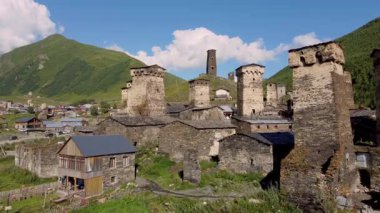 Görkemli taş kuleler ve geleneksel evler Ushguli, Svaneti, Gürcistan, UNESCO Dünya Mirası İnsansız Hava Aracı Bölgesi 'ndeki yemyeşil dağların karşısında duruyor..