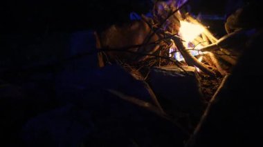Kıvılcımlar ateş yakar, ve tutuşturma gazındaki odun ve sıvı sıcak, çatırdayan bir ateş yaratır. Kayalar kamp ateşinin etrafını sarar, açık hava atmosferini arttırır.