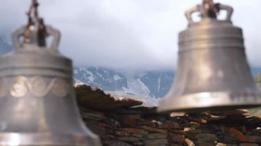 Arka plandaki dağ tapınağına asılı büyük bronz çanlar karlı tepe ve yeşil yamaçlar Lomaria Kilisesi 'ndeki tarihi Kafkas manzarasının ruhani sükunetini ve kültürel mirasını temsil ediyor.