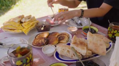 Taze sebzeler, tortillalar, krepler ve çeşitli yemeklerle nefis fresk kahvaltı masası. Renkli ve rahat sabah yemeğinin mükemmel tasviri