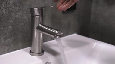 El yıkama işlemi, musluklardaki su ve akan suyla ilgili eksiksiz temizlik tekniği, köpüklü eller, durulama ve temiz banyodaki fazla nemi temizleme.