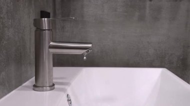 Çağdaş, paslanmaz çelik musluktan damlayan su damlacıkları, tesisat sorunları, su atıkları ve tamir ya da yenileme ihtiyacı