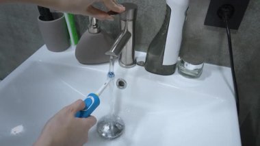 Diş fırçasına diş macunu süren kadın, Yavaş Hareket eden kadın elleri elektrikli diş fırçası tutan ve diş macunu süren kadın.