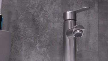 Çağdaş, paslanmaz çelik musluktan damlayan su damlacıkları, tesisat sorunları, su atıkları ve tamir ya da yenileme ihtiyacı