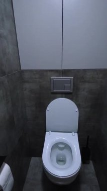 Profesyonel tesisatçı banyo dolabını açar ve kapatır. Su boruları ve diğer tesisat tesisatlarını gösterir. Bakım ve teftiş prosedürlerini dikey gösterir.