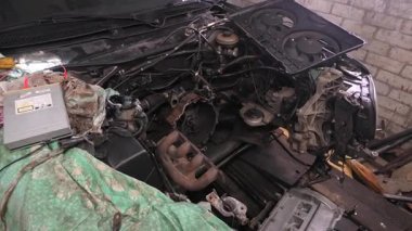 Araba motorundan egzoz manifoldu, profesyonel garaj ortamında detaylı araba tamir işlemi sırasında karmaşık iç bileşenleri açığa çıkarıyor
