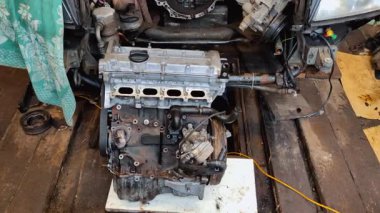detaylı motor parçalanması, iyi organize edilmiş garaj çalışma alanındaki karmaşık mekanik bileşenleri ortaya çıkarmak, araba tamiri sürecini aydınlatıyor. Motorsuz araba.
