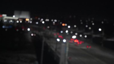 Gece vakti, parlak ışık yollarıyla parlayan şehir otoyolu, trafik şablonlarını, aydınlık enerji ve metropoliten hareketin büyüleyici bokeh akışına dönüştürüyor.