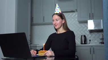 Doğum gününü arkadaşları ve ailesiyle birlikte kutlayan bir kadın, VoIP çağrısı sırasında, salgın sırasında sanal bir parti veriyor. Sosyal uzaklık uygulamaları. Doğum günü yaşam tarzı teması