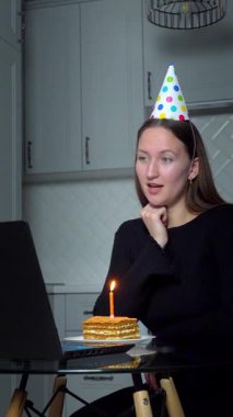 Doğum gününü arkadaşları ve ailesiyle birlikte kutlayan bir kadın, VoIP çağrısı sırasında, salgın sırasında sanal bir parti veriyor. Sosyal uzaklık uygulamaları. Doğum günü temalı dikey video