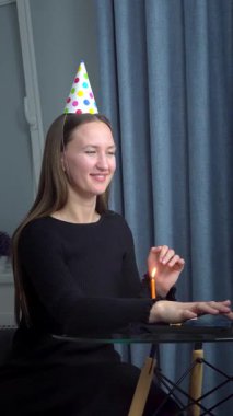 Doğum gününü arkadaşları ve ailesiyle birlikte kutlayan bir kadın, VoIP çağrısı sırasında, salgın sırasında sanal bir parti veriyor. Sosyal uzaklık uygulamaları. Doğum günü temalı dikey video