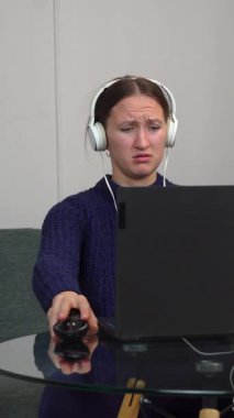 Çevrimiçi oyun oynayan, kulaklık takan, bilgisayar ve fare kullanarak sanal dünyada gezinen genç bir kadın.