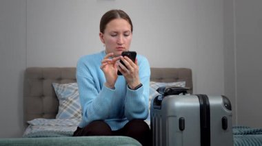 Akıllı telefon planlarını kullanan bir kadın uçak bileti, otel, ulaşım, iş seyahatine hazırlanmak, rotaları kontrol etmek, mobil uygulama kullanarak taksi çağırmak gibi seyahatler yapar.