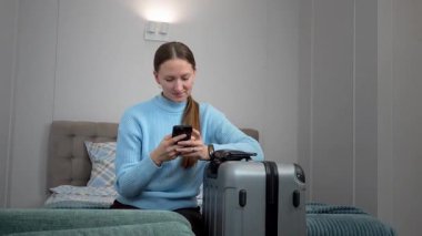 Akıllı telefon planlarını kullanan bir kadın uçak bileti, otel, ulaşım, iş seyahatine hazırlanmak, rotaları kontrol etmek, mobil uygulama kullanarak taksi çağırmak gibi seyahatler yapar.