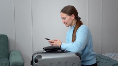 Akıllı telefon planlarını kullanan bir kadın uçak bileti, otel, ulaşım, iş seyahatine hazırlanmak, rotaları kontrol etmek, mobil uygulama kullanarak taksi çağırmak gibi seyahatler yapar.