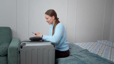 Akıllı telefon planlarını kullanan bir kadın uçak bileti, otel, ulaşım, iş seyahatine hazırlanmak, rotaları kontrol etmek, mobil uygulama kullanarak taksi çağırmak gibi seyahatler yapar.