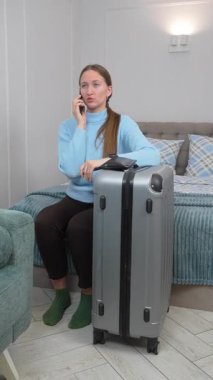 Turist gergin bir şekilde otel yatağında bavullarının yanında oturuyor. Acil bir telefon görüşmesi. Endişeli bir ifadeyle seyahatin olası komplikasyonlarını tartışıyorlar.