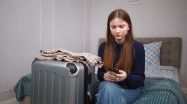 Genç kız otelde yatakta dinleniyor, çantanın yanındaki akıllı telefonu kontrol ediyor, dijital kolaylıkla yaklaşan yolculuğa hazırlanıyor, bir taksi çağırıyor.