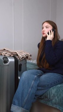 Genç kız otelde yatakta dinleniyor, çantanın yanındaki akıllı telefonu kontrol ediyor, dijital rahatlıkla yaklaşan yolculuğa hazırlanıyor, bir taksi videosunu dikey olarak arıyor.