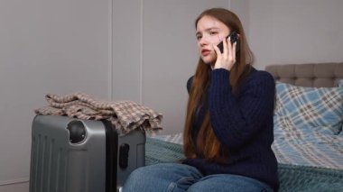 Heyecanlı genç kız valizinin yanında oturuyor, telefon görüşmeleri duygusal bir yolculuğa hazırlanıyor, yaklaşan yolculuktan korkuyor.